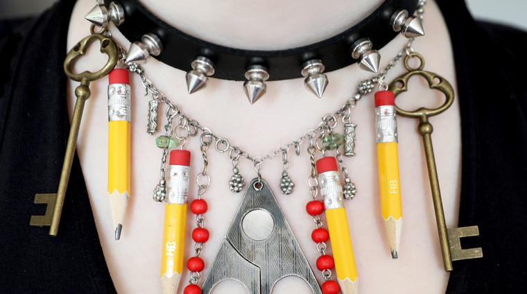 Ett egetpysslat halsband med pärlor, nycklar och pennor som hängen